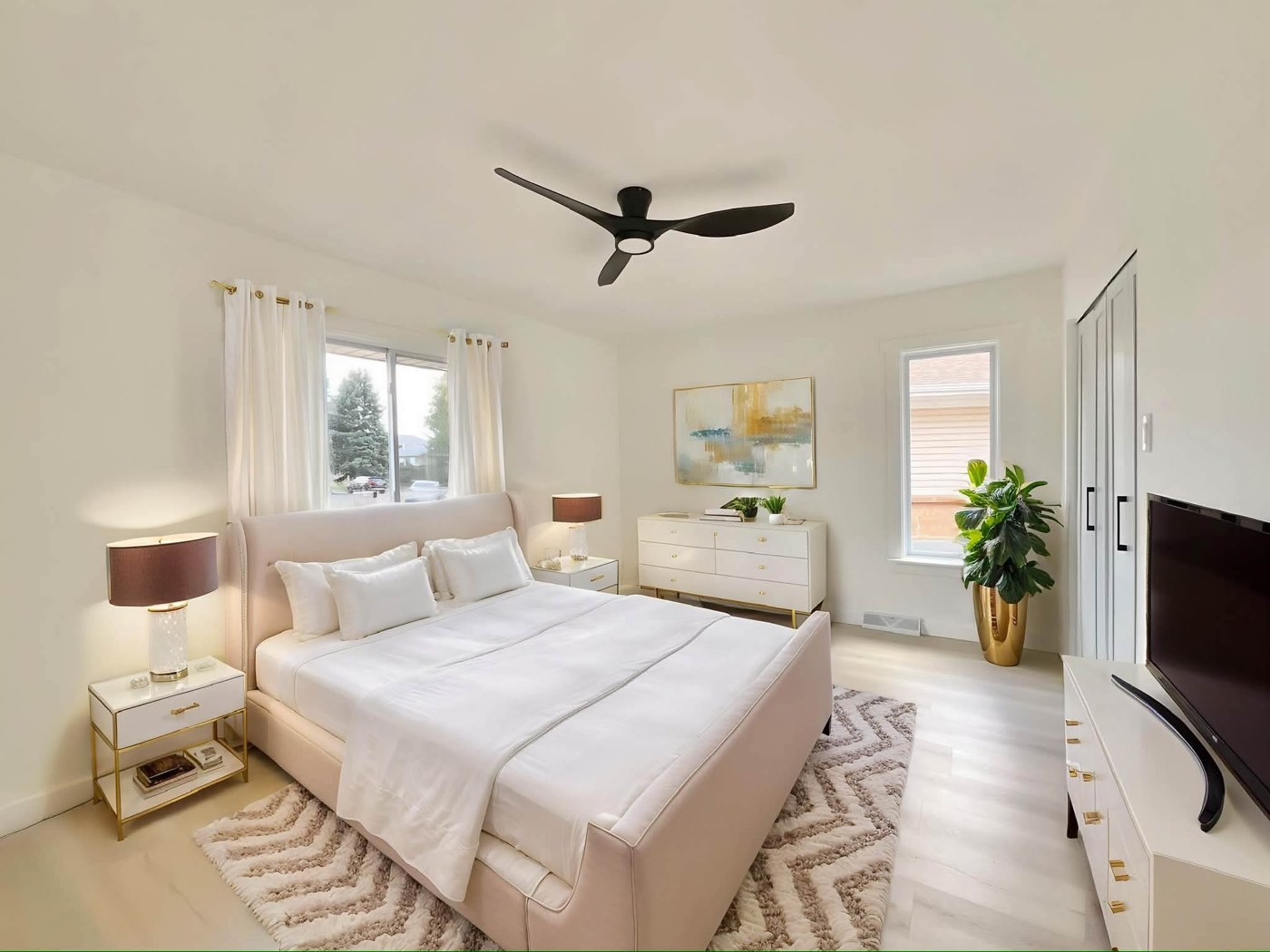 Remodeled bedroom with a ceiling fan and large windows
