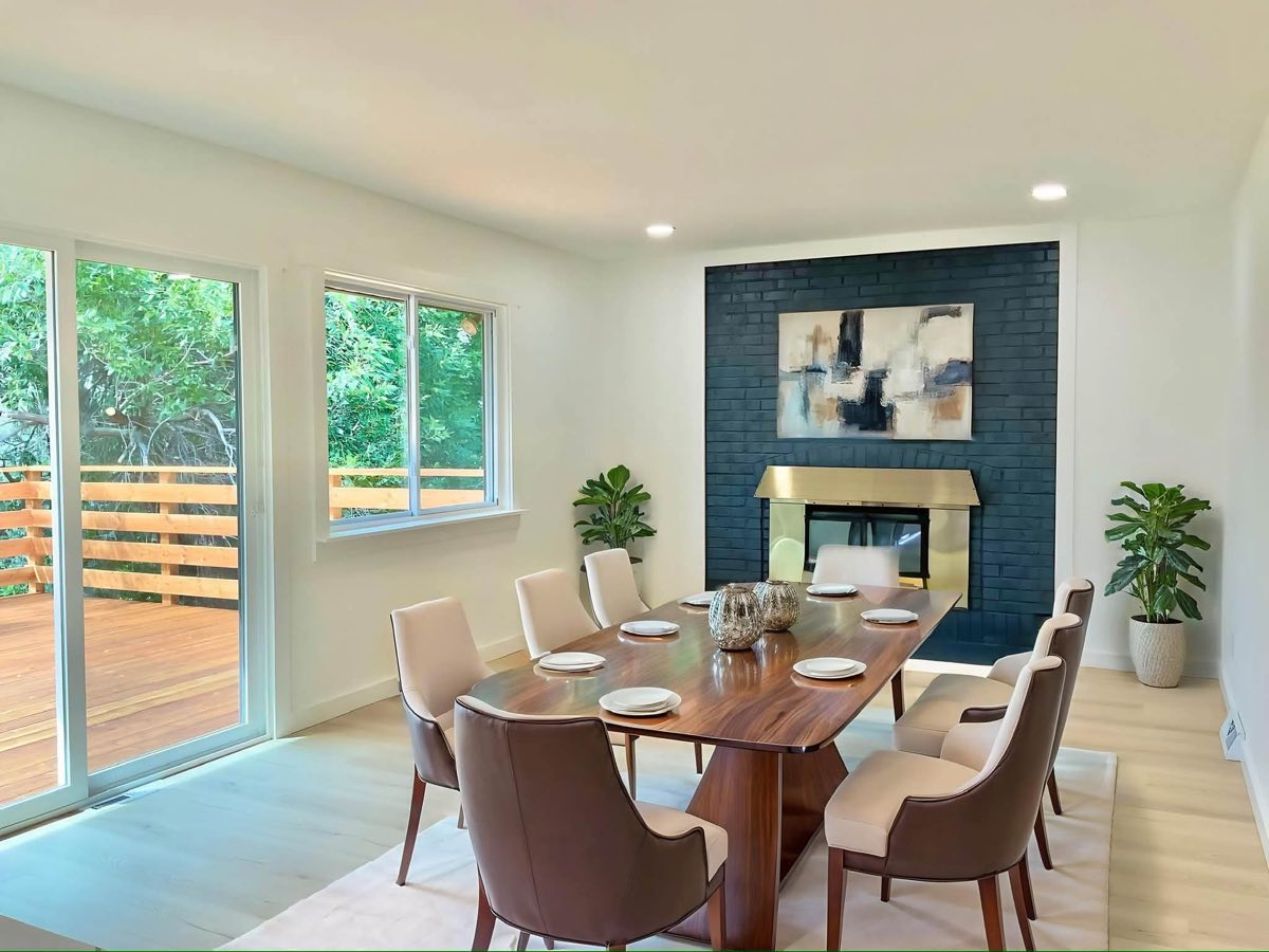 Dining room next to a fireplace with a dark tile surround