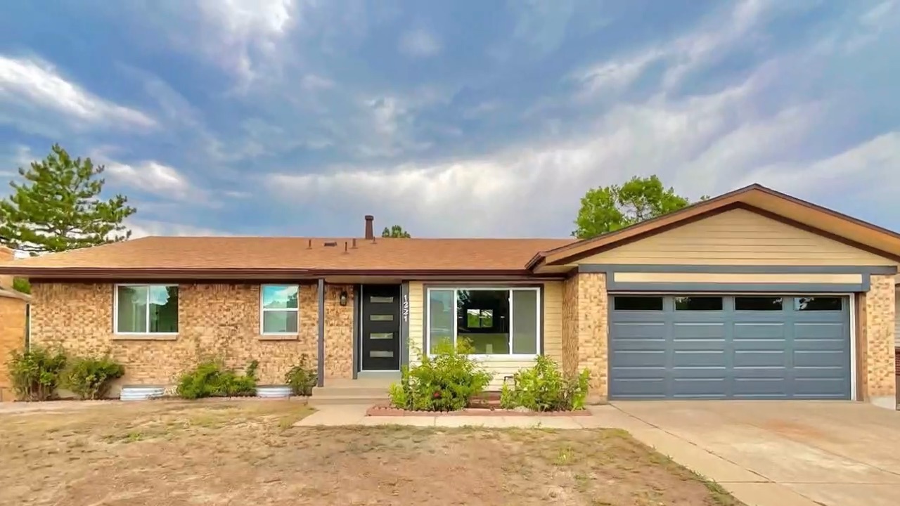 Remodeled brick ranch home with a new front door and garage door