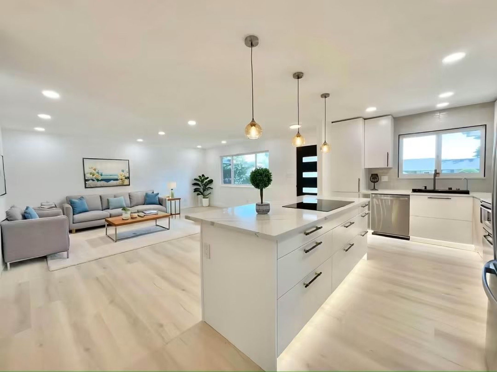 White kitchen island with pendant lights and under-cabinet lighting