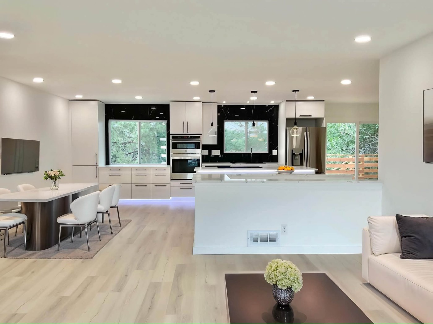 Remodeled white kitchen with a waterfall island and black window frames