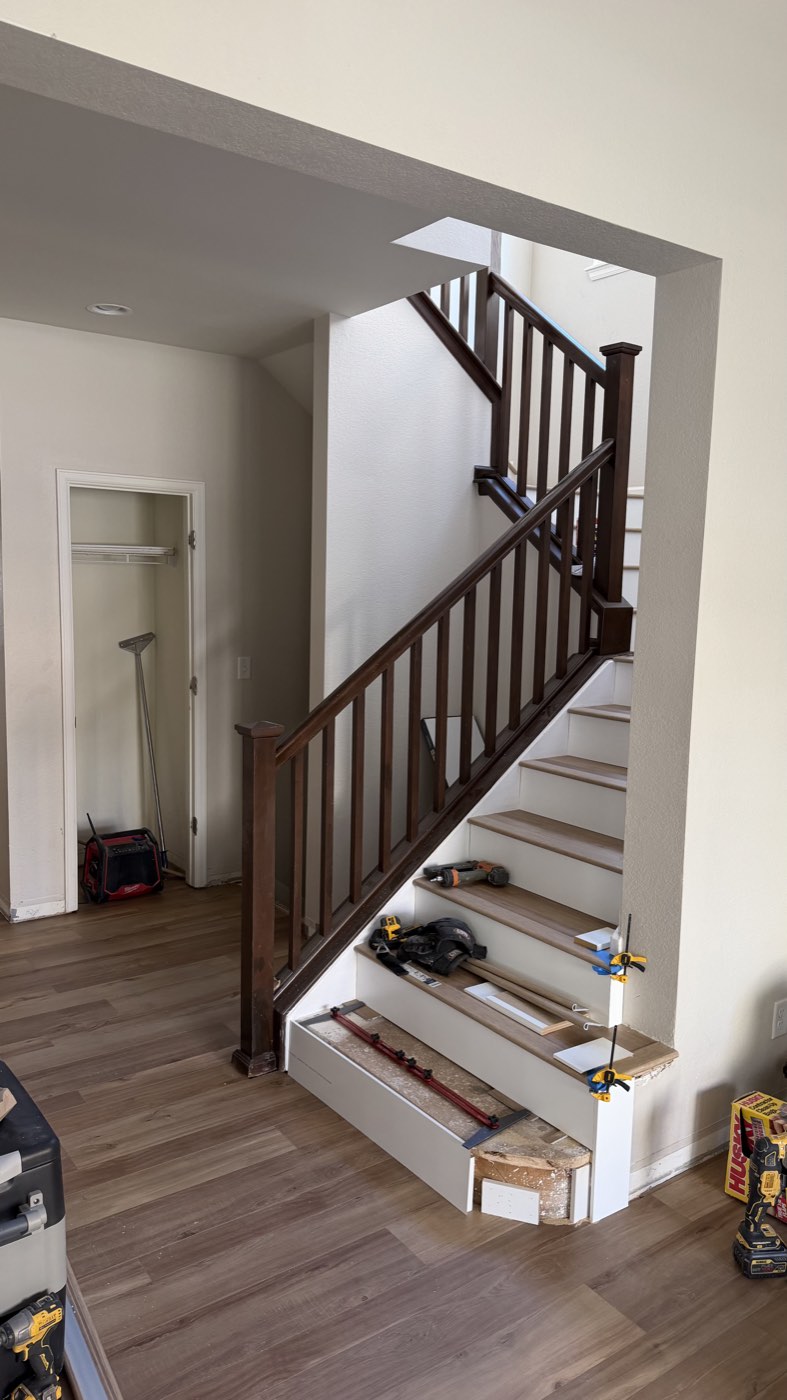 Staircase and landing with new flooring and dark wood railing